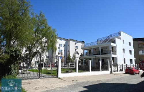 a white building with a fence in front of it at Mida Summer Villa in Mamaia Sat/Năvodari