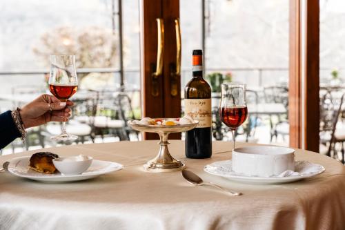 a person holding a glass of wine on a table at Hotel Ristorante La Quartina in Mergozzo