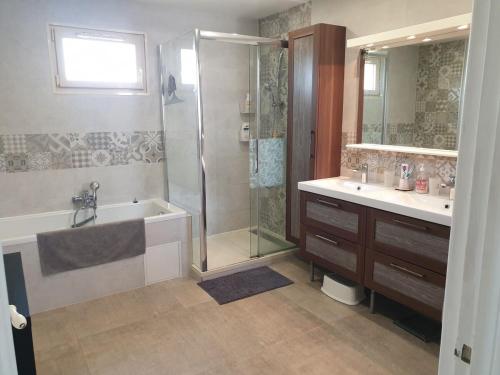 une salle de bain avec une douche, une baignoire et un lavabo dans l'établissement Family vacation home, à Mouans-Sartoux