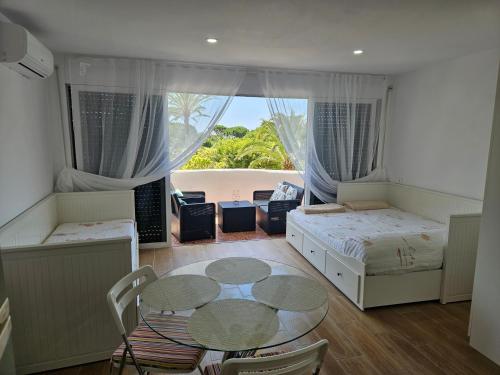 a room with two beds and a table and a window at Julia's apartment in Marbella