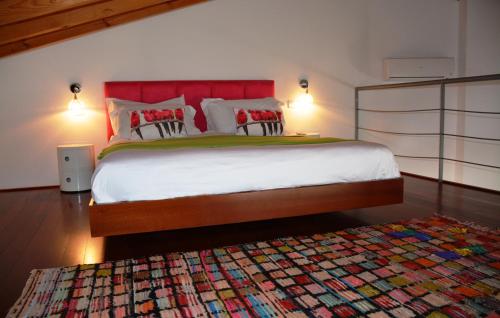 a bedroom with a large bed with a colorful rug at Tavira House in Tavira