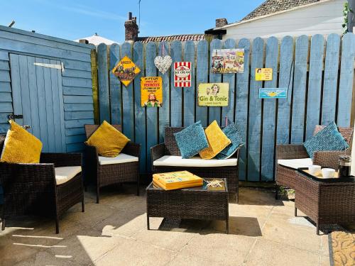a group of chairs with colorful pillows in front of a fence at Host & Stay - Beckside in Pickering