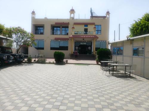 a building with tables and chairs in front of it at Hotel Royal Fort in Gurgaon