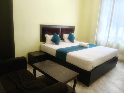 a bedroom with a large bed with blue pillows at Hotel Royal Fort in Gurgaon