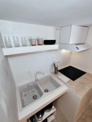 a small white kitchen with a sink in it at Milos Pollonia Apartment in Mesochórion