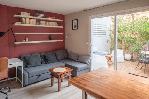un salon avec un canapé et une table dans l'établissement Charmant appartement avec jardin à 500m des plages Prado Borely, à Marseille