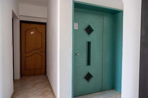 a green door in a hallway next to a wooden door at AVENA Suites in Kato Gouves