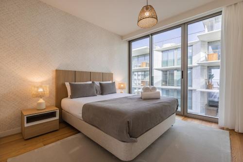 a bedroom with a large bed and a large window at Ocean View Luxury Bayline Apartment in Armação de Pêra