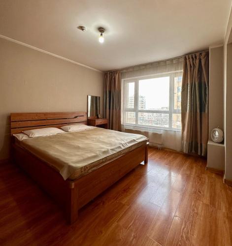 a bedroom with a large bed and a large window at Your home in Ulaanbaatar in Ulaanbaatar