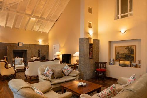 a living room with couches and a fireplace at Grand Bungalow Nuwara Eliya by Seven Angels in Nuwara Eliya