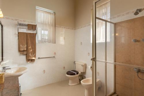 a bathroom with a toilet and a sink and a shower at Grand Bungalow Nuwara Eliya by Seven Angels in Nuwara Eliya