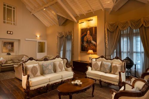 a living room with couches and a table at Grand Bungalow Nuwara Eliya by Seven Angels in Nuwara Eliya