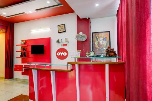 Una pared roja en una habitación con un televisor. en Hotel O Elibrista, en Meerut