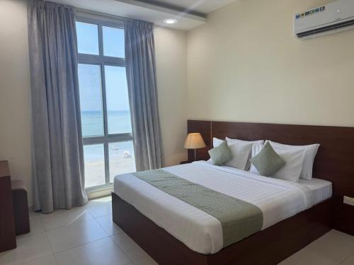a bedroom with a bed with a view of the ocean at Marine Beach Apartment in Seef