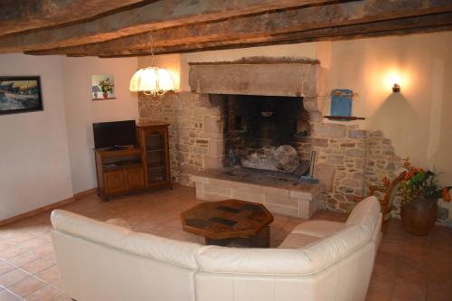un salon avec un canapé et une cheminée dans l'établissement La Prairie, à La Celle-sous-Gouzon