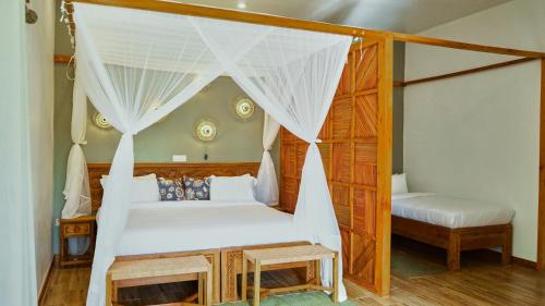 a bedroom with a bed and a canopy bed at Mateves boutique lodge in Arusha