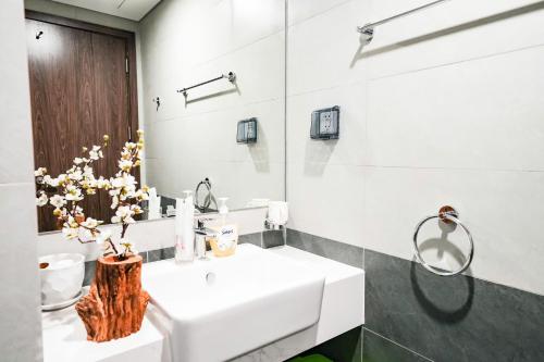 a bathroom with a white sink and a mirror at Shi House - 2BR Building BE2 Luxury, Park View in Long Bình