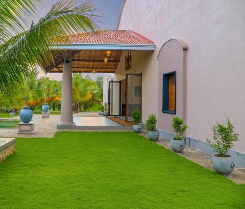 a house with a green lawn in front of it at Villa Green Cocos in Katuwana