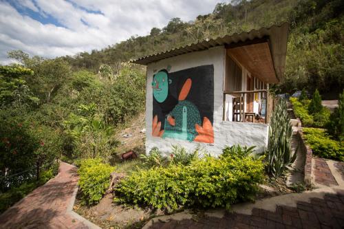 a house with a painting on the side of it at HOTEL LA SELVA Reserva in La Vega