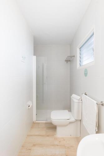 a white bathroom with a toilet and a shower at Sol Parc Hotel & Apartments in Son Parc