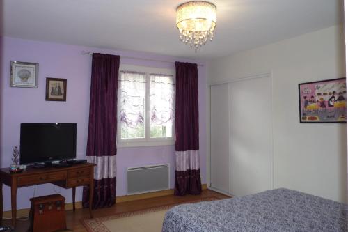 a bedroom with a bed and a window and a television at Villa hameau paisible Ardouane, à côté voie verte in Riols