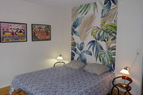 a bedroom with a bed with two lamps and a mural at Villa hameau paisible Ardouane, à côté voie verte in Riols