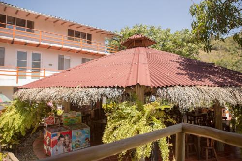 a gazebo with a red roof in front of a building at HOTEL LA SELVA Reserva in La Vega