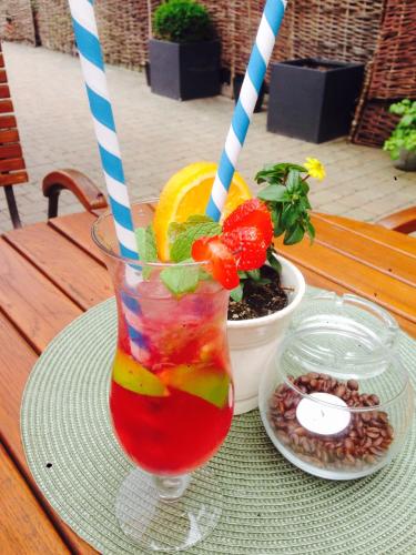 a drink with two straws in a glass on a table at Piwnica Rycerska Kęty in Kęty