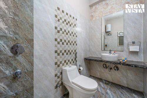 a bathroom with a white toilet and a sink at StayVista at Sitara with Jacuzzi & WiFi in Jaipur