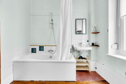 une salle de bain blanche avec une baignoire et un lavabo dans l'établissement Le Gabriel - F2-4 pers-10min Gare & Nancy Thermal, à Nancy