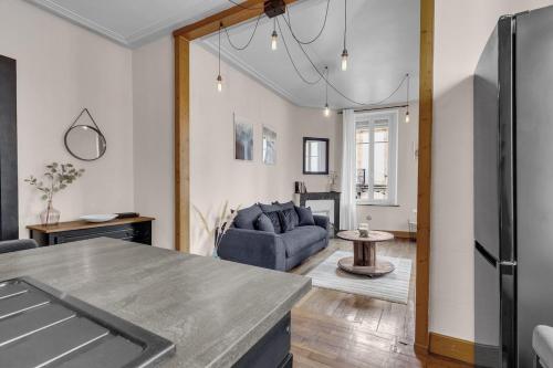 Il comprend une cuisine et un salon doté d'un canapé bleu. dans l'établissement Le Gabriel - F2-4 pers-10min Gare & Nancy Thermal, à Nancy