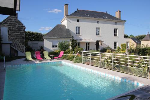 a swimming pool in front of a house at Doué's Mansion in Doué-la-Fontaine