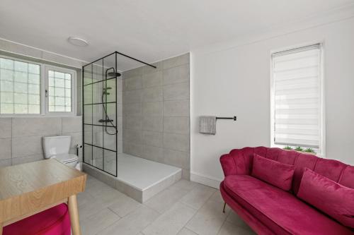 a living room with a red couch and a bathroom at SPA Cottage With Mineral Water in Stamford