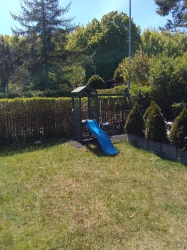 a playground in a yard with a blue slide at Domki na Stoku Nadole in Nadole