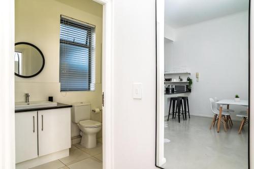 a bathroom with a sink and a toilet in a room at Muizenberg Coastal Hideaway by Surfers Corner in Muizenberg