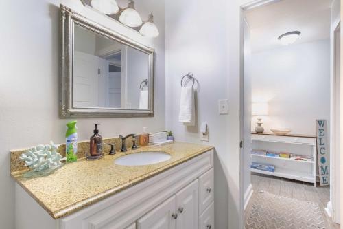 a bathroom with a sink and a mirror at Coastal-Chic Condo Steps from the Sand in Destin