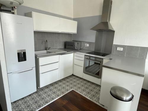 une petite cuisine avec des armoires blanches et un évier dans l'établissement T2 lumineux en hyper centre, à Aix-en-Provence