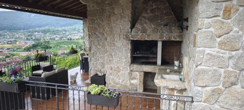 a stone building with a fireplace on a balcony at O Piñón in Santa Cristina de Cobres