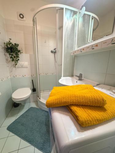 a bathroom with a shower and a yellow blanket at Old town cozy Studio in City Center in Bratislava