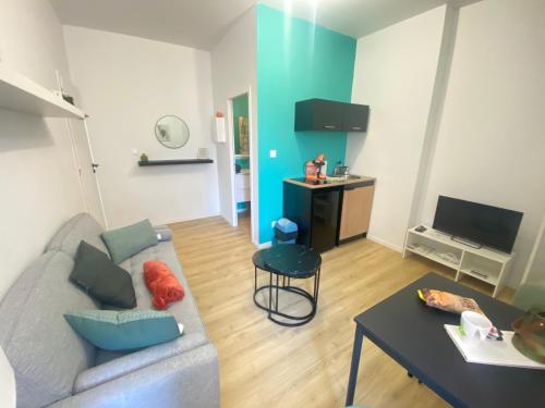 un salon avec un canapé et une table dans l'établissement Appt RDC Jardin Laverie Parking Villa Margareth, à Dunkerque