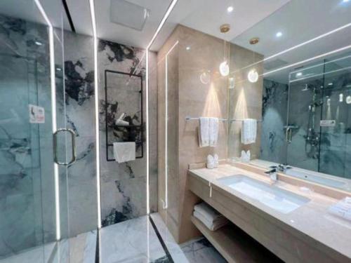 une salle de bain avec un lavabo et une douche en verre dans l'établissement Sanya Yellow River Kyoto Hotel, à Sanya