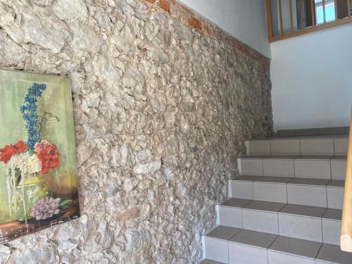 a painting of flowers in a vase on a stone wall at Haus Kampl - Appartement Ödensee in Obersdorf