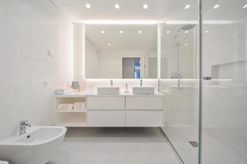 a white bathroom with a sink and a shower at In-Town Residences in Funchal