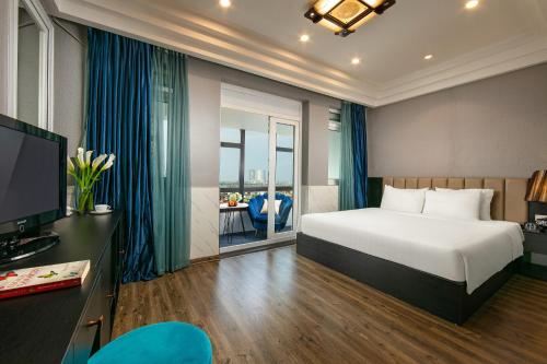 a hotel room with a bed and a television at Ja Cosmo Hotel and Spa in Hanoi