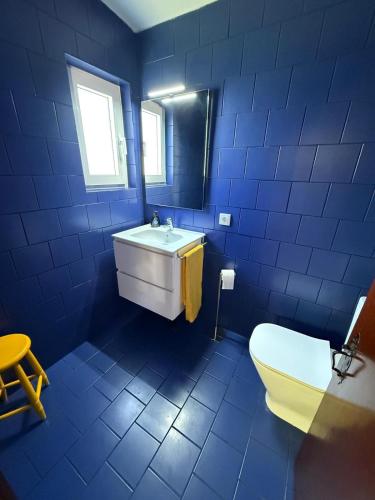a blue bathroom with a sink and a toilet at Casa da Ingrina in Raposeira
