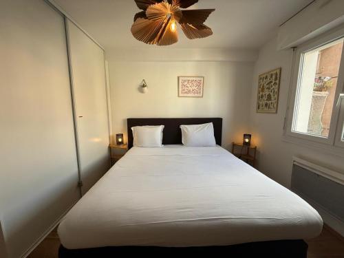 une chambre avec un grand lit blanc avec un lustre dans l'établissement Petite France avec 1 Parking, à Strasbourg