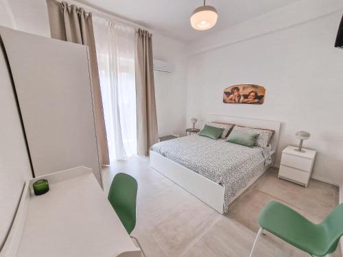 een slaapkamer met een bed, een tafel en stoelen bij Holy Dove by Wonderful Italy in Cefalù