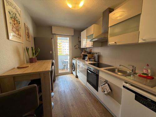 une cuisine avec une table, un évier et un comptoir dans l'établissement Petite France avec 1 Parking, à Strasbourg