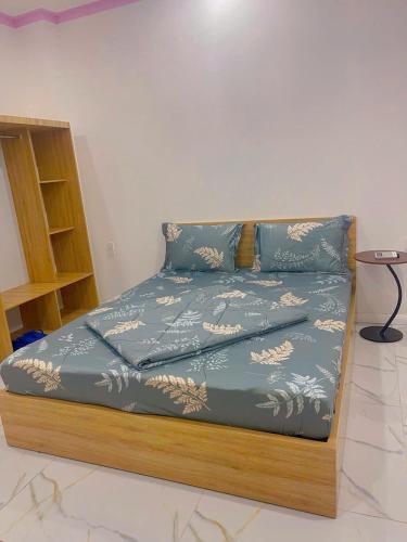 a bed with a blue comforter on top of it at Khách sạn LyLy 3 in Thuan An