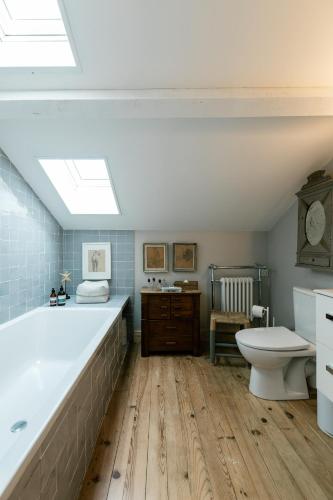 La salle de bains est pourvue d'une grande baignoire et de toilettes. dans l'établissement Maison de vacances Le Bosquet, à Saint-Julien-en-Born